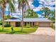 Charming home featuring a stone facade, metal roof, and well-manicured landscaping at 108 Dee St, New Smyrna Beach, FL 32168