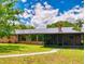 A single-story home featuring a screened in patio and brick exterior at 108 Dee St, New Smyrna Beach, FL 32168