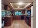 Traditional kitchen with wood cabinets, black appliances, light wood floors and a window overlooking the backyard at 108 Dee St, New Smyrna Beach, FL 32168