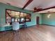 Spacious room with hardwood floors, exposed wood beams, decorative mirrors and a ceiling fan at 108 Dee St, New Smyrna Beach, FL 32168