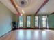 Bright living room with hardwood floors, exposed beams, and large, well-lit windows with unique designs at 108 Dee St, New Smyrna Beach, FL 32168
