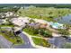 Aerial view of the clubhouse, pool, golf course, and lush landscaping in a luxurious community at 113 Pitching Wedge Dr, Daytona Beach, FL 32124