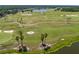 Scenic aerial view of the golf course with lush greens, sand traps, and serene lake views at 113 Pitching Wedge Dr, Daytona Beach, FL 32124