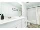 Bathroom features double sink vanity, large mirror, shower with curtain and white cabinets and lots of light at 113 Pitching Wedge Dr, Daytona Beach, FL 32124