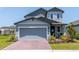 Charming two-story home featuring a two-car garage, brick driveway, and tasteful landscaping at 113 Pitching Wedge Dr, Daytona Beach, FL 32124