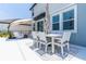 Covered patio with dining table, white cushioned chairs, and an umbrella at 113 Pitching Wedge Dr, Daytona Beach, FL 32124