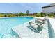 Inviting pool with shallow lounge chairs, surrounded by landscaped gardens at 113 Pitching Wedge Dr, Daytona Beach, FL 32124