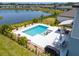 Aerial view of a backyard with a stunning pool and a relaxing patio area by the lake at 113 Pitching Wedge Dr, Daytona Beach, FL 32124