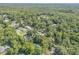 Aerial shot of real estate among dense foliage and scattered homes at 1144 Corbin Park Rd, New Smyrna Beach, FL 32168