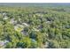 Aerial shot of real estate among dense foliage and scattered homes at 1144 Corbin Park Rd, New Smyrna Beach, FL 32168
