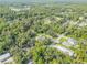 Real estate aerial showing home in a densely wooded area with a lake nearby at 1144 Corbin Park Rd, New Smyrna Beach, FL 32168