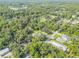 Real estate aerial showing home in a densely wooded area with a lake nearby at 1144 Corbin Park Rd, New Smyrna Beach, FL 32168