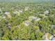 Real estate aerial view of a neighborhood, featuring dense trees and a few houses at 1144 Corbin Park Rd, New Smyrna Beach, FL 32168