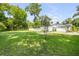 Expansive backyard with lush green grass and mature trees, offering privacy and space at 1144 Corbin Park Rd, New Smyrna Beach, FL 32168