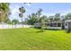 Large backyard features a screened-in porch, lush lawn, and full fence at 1144 Corbin Park Rd, New Smyrna Beach, FL 32168