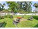 Spacious backyard featuring a stone patio with Adirondack chairs and lush landscaping at 1144 Corbin Park Rd, New Smyrna Beach, FL 32168