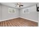 Bedroom featuring wood-look floors, neutral walls, two windows with blinds and a ceiling fan at 1144 Corbin Park Rd, New Smyrna Beach, FL 32168