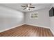 This is a bedroom with light gray walls, ceiling fan, wood-look floors, and a window with shutters at 1144 Corbin Park Rd, New Smyrna Beach, FL 32168