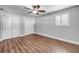 A bright bedroom features wood-look floors, ceiling fan, window with blinds, and closet for storage at 1144 Corbin Park Rd, New Smyrna Beach, FL 32168