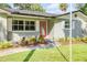 Close-up of the front entrance with a bright red door and colorful landscaping at 1144 Corbin Park Rd, New Smyrna Beach, FL 32168