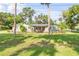 Charming single-story home with well-maintained landscaping and a bright red front door at 1144 Corbin Park Rd, New Smyrna Beach, FL 32168