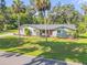 Charming single-story home with well-maintained landscaping and a bright red front door at 1144 Corbin Park Rd, New Smyrna Beach, FL 32168