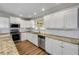 Bright kitchen featuring white cabinets, stainless appliances, granite countertops, and wood floors at 1144 Corbin Park Rd, New Smyrna Beach, FL 32168
