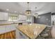 Bright kitchen featuring white cabinets, a large island, and granite countertops at 1144 Corbin Park Rd, New Smyrna Beach, FL 32168