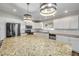 Modern kitchen with an island, stainless appliances, granite countertops, and stylish pendant lighting at 1144 Corbin Park Rd, New Smyrna Beach, FL 32168