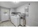 Well-lit laundry room with tile flooring, modern washer and dryer, shelving and convenient exterior door at 1144 Corbin Park Rd, New Smyrna Beach, FL 32168