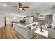 Open-concept living space with hardwood floors, modern furniture, and a seamless flow to the kitchen and dining area at 1144 Corbin Park Rd, New Smyrna Beach, FL 32168
