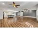 Spacious living room with hardwood floors, ceiling fans, and open layout to kitchen at 1144 Corbin Park Rd, New Smyrna Beach, FL 32168