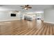 Open-concept living room featuring hardwood floors and a view of the modern kitchen at 1144 Corbin Park Rd, New Smyrna Beach, FL 32168