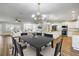 Open living space with a dining table, kitchen island, stainless appliances, and adjacent seating area for seamless flow at 1144 Corbin Park Rd, New Smyrna Beach, FL 32168
