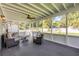 Covered and screened porch with neutral-toned furnishings and view of the landscaped backyard at 1144 Corbin Park Rd, New Smyrna Beach, FL 32168