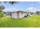 The backyard features a well maintained lawn with the building and a screened in patio in the background at 125 Orange Ave, Edgewater, FL 32132