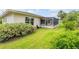 The backyard features a well maintained lawn with the building and a screened in patio in the background at 125 Orange Ave, Edgewater, FL 32132