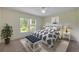 Bright bedroom featuring a large window, a decorative plant, and a patterned king-sized bed at 125 Orange Ave, Edgewater, FL 32132