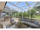 Enclosed patio with comfortable seating, a dining area, and views of the surrounding greenery at 125 Orange Ave, Edgewater, FL 32132