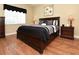 Elegant bedroom with a dark wood bed frame, stylish bedding, and hardwood floors at 1442 Carlow Cir, Ormond Beach, FL 32174