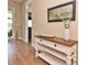 Inviting foyer with wood floors, a decorative table, mirror, and front door leading to a bright sunroom at 1442 Carlow Cir, Ormond Beach, FL 32174
