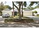 Charming home featuring a three-car garage, manicured lawn, and mature trees at 1442 Carlow Cir, Ormond Beach, FL 32174
