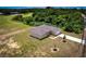 Aerial view of home with covered patio and driveway surrounded by green lawns and mature trees at 15190 Cr-565A, Clermont, FL 34711
