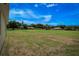 Expansive backyard featuring lush lawn and views of neighboring homes and mature trees under a blue sky at 15190 Cr-565A, Clermont, FL 34711
