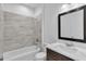 Bathroom featuring a combination tub and shower, modern vanity, and elegant mirror at 15190 Cr-565A, Clermont, FL 34711