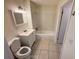 Full bathroom with white vanity, toilet, shower-tub, and tile floors under decorative vanity lighting at 1600 Big Tree Rd # L1, South Daytona, FL 32119