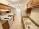 Bright kitchen with white appliances, wood cabinets, and a double basin sink at 1600 Big Tree Rd # L1, South Daytona, FL 32119