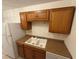 Kitchen with wood cabinets, white appliances including a double basin sink at 1600 Big Tree Rd # L1, South Daytona, FL 32119