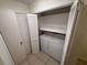 Laundry closet featuring a stacked washer and dryer and ventilated shelving at 1600 Big Tree Rd # L1, South Daytona, FL 32119