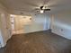 Open-concept living room with views into kitchen and laundry area, featuring a ceiling fan and wood-look flooring at 1600 Big Tree Rd # L1, South Daytona, FL 32119